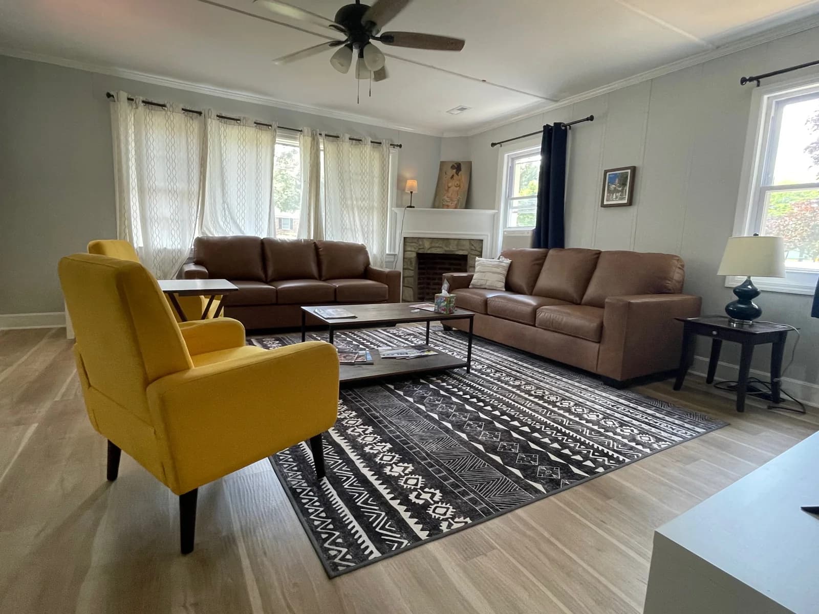 Shared living room with brown sofas, yellow chairs, and a coffee table.